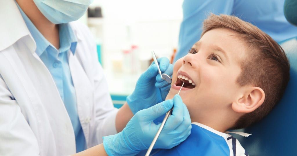 Dentist examining little boy's teeth