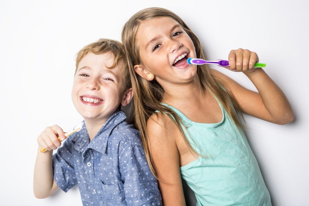Brother and sister brushing teeth
