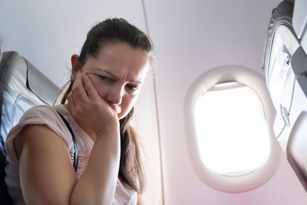 Woman with toothache on plane